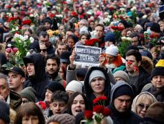 Скорбящие идут на Борисовское кладбище во время похорон Алексея Навального. На плакате написано: 